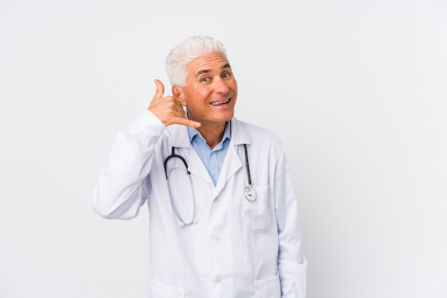 Mature caucasian doctor man showing a mobile phone call gesture with fingers.