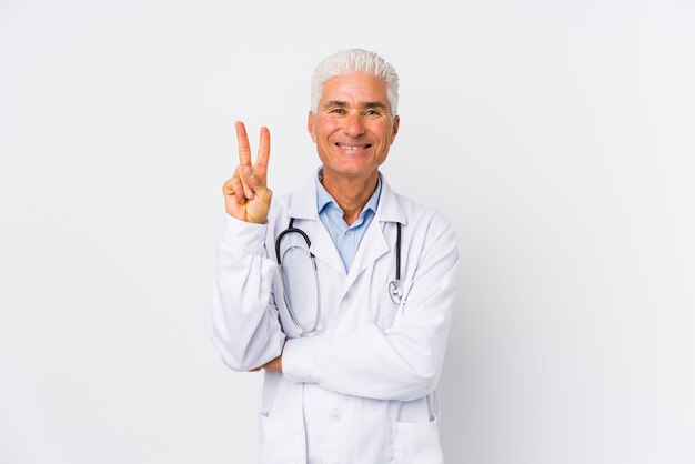 Mature caucasian doctor man showing number two with fingers.