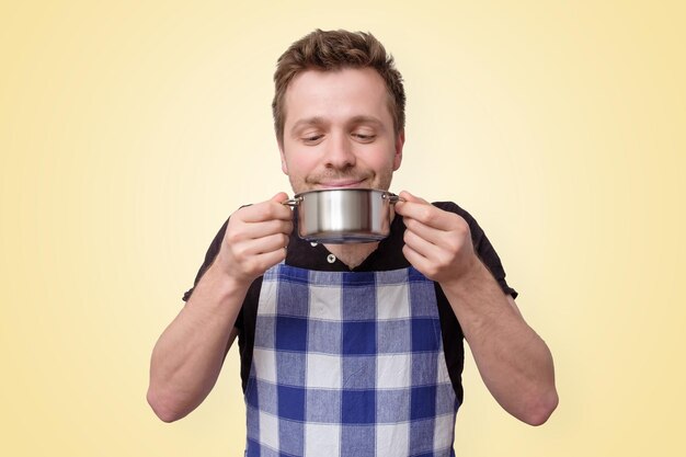 Photo mature caucasian man holding a pan with tasty meal