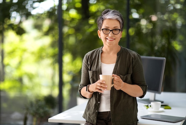 Mature corporate businesswoman have coffee break at home office