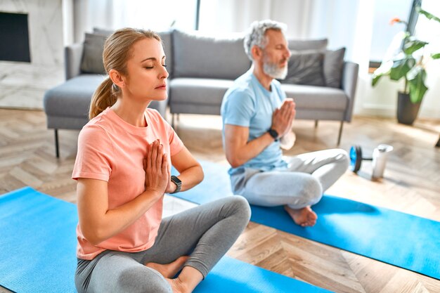 Mature couple doing exercise or yoga at home