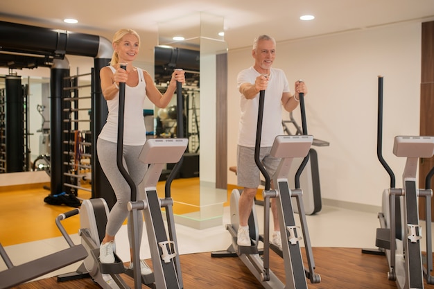 Mature couple exercising together in the gym