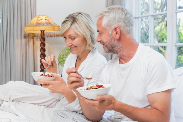 Mature couple having breakfast in bed