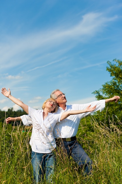Mature couple having fun in a sunny meadow