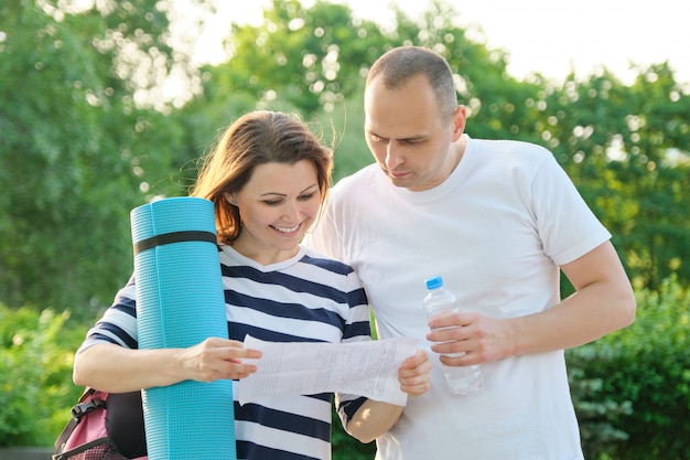 Mature couple reading paper document letter outdoor