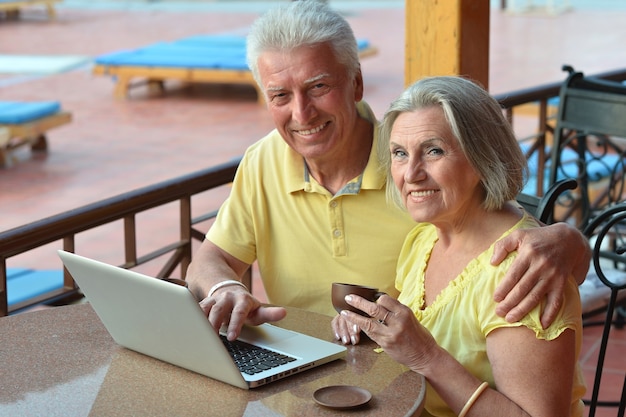 Mature couple sitting with laptop  in hotel