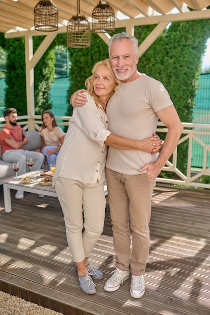 A mature couple standing close and looking happy