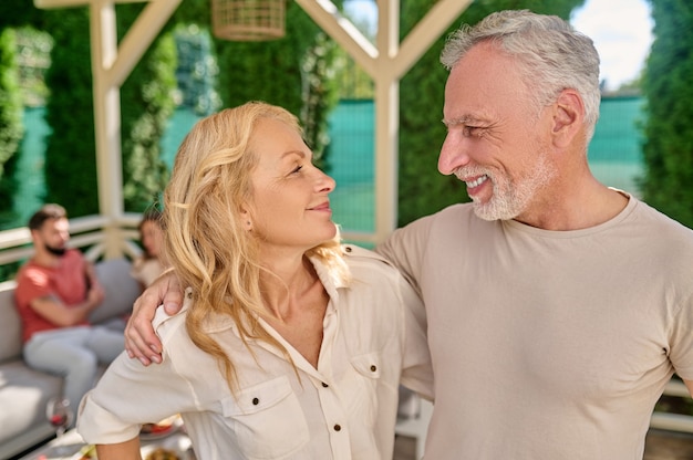 A mature couple standing close and looking happy