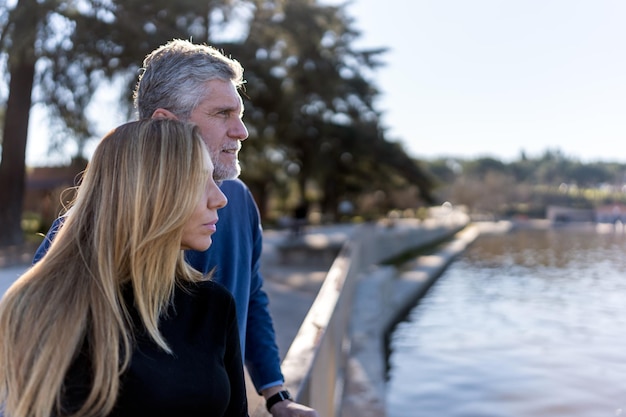 Mature couple standing near river in park