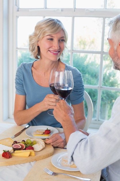 Mature couple toasting wine glasses over food