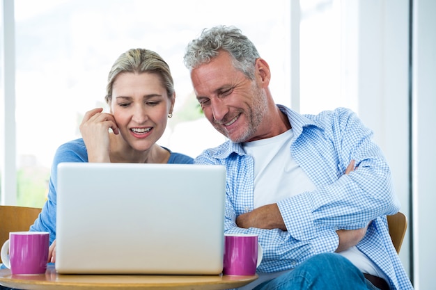 Mature couple using laptop at home