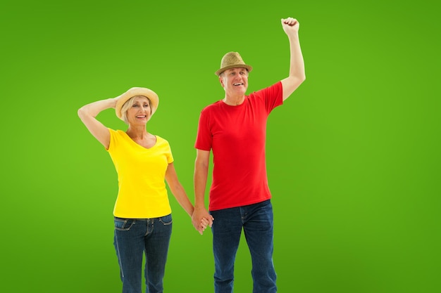 Mature couple walking and holding hands against green vignette