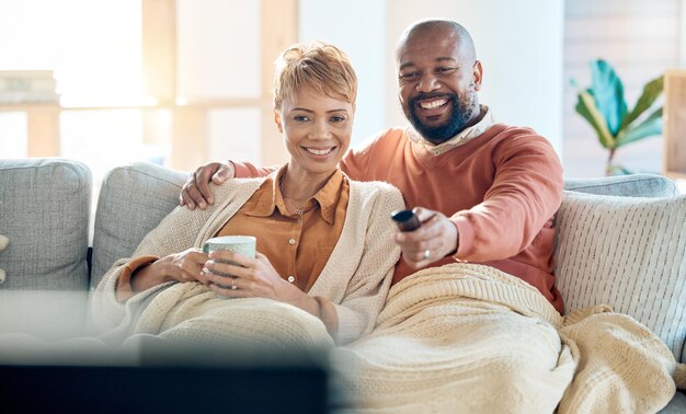 Mature couple watching tv news and movie cable show and media broadcast living room sofa and easy lifestyle Happy smile and black people change remote television subscription and home streaming