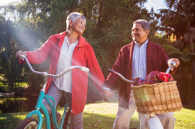 Mature couple with bicycle at park