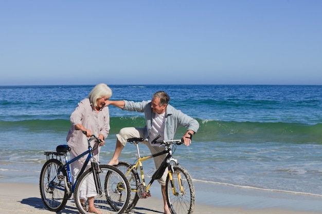 Mature couple with their bikes on the beach