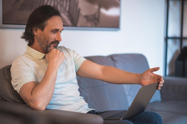 Mature dark-haired man working remotely from home