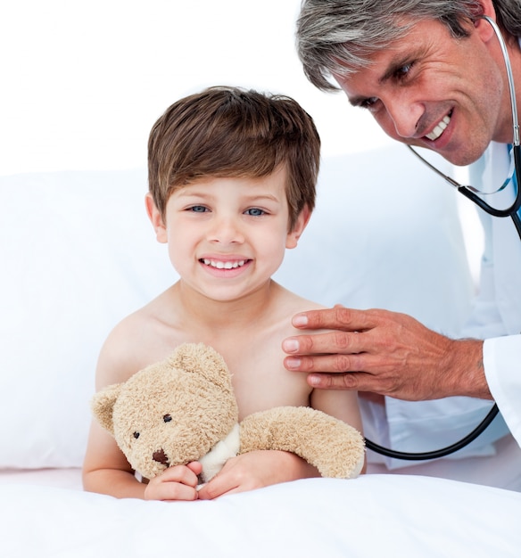 Mature doctor checking little boy's pulse 