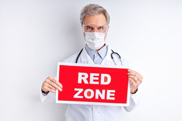 Mature doctor male with RED ZONE prescription on tablet