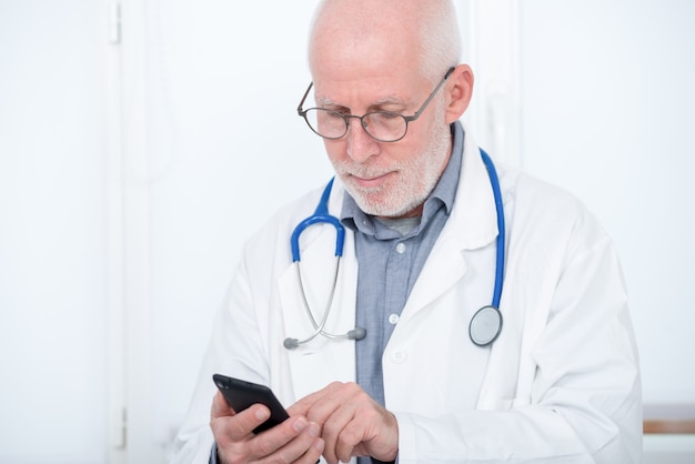 Mature doctor on phone in his office