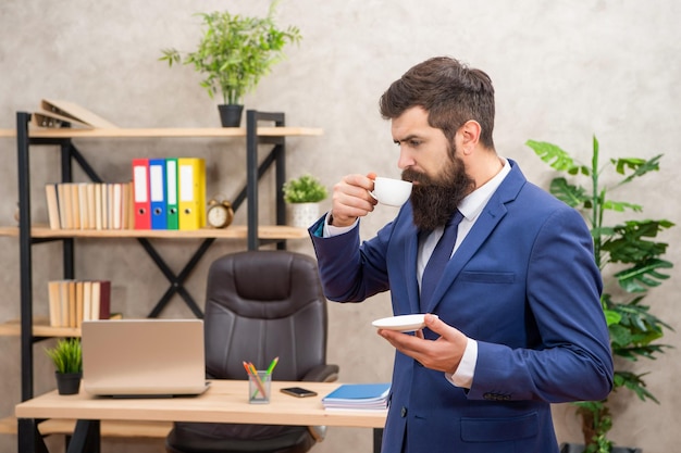 Mature entrepreneur in jacket have coffee break at office businessperson