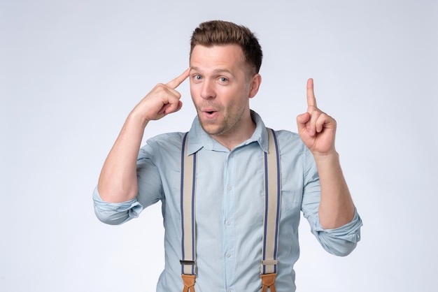 Mature european man holds finger on temple he generated a great idea and had the best plan what to do now