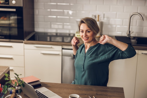 Mature female entrepreneur taking a break while working from her home office.