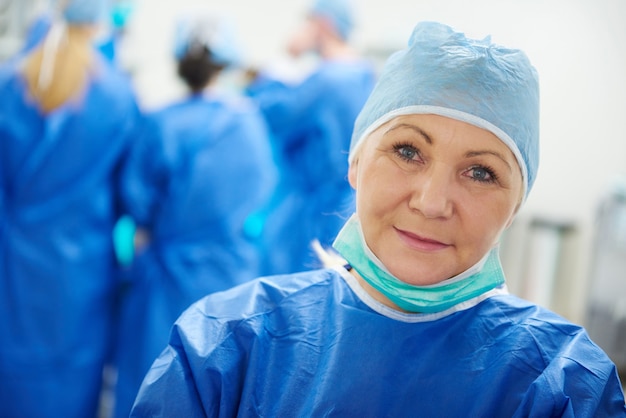 Chirurgo femminile maturo in berretto chirurgico