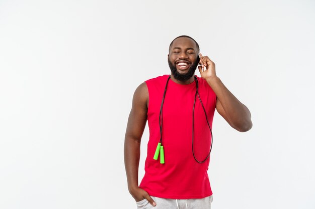 Mature fit African American man talking on mobile and holding elastic rope.