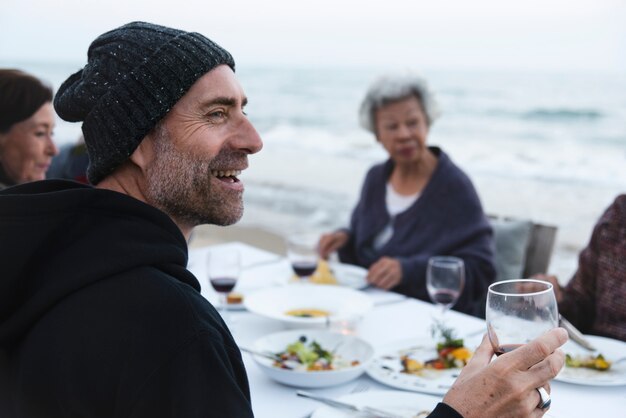 Mature friends drinking wine at the beach