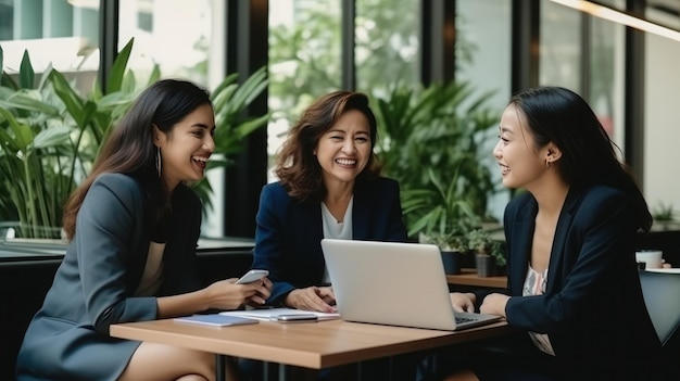 노트북을 사용하는 성숙한 그룹 사업가 여성이  사무실에서 친구와 웃으며 이야기합니다.