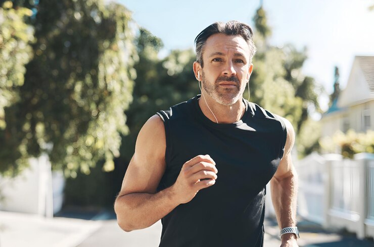 Photo mature guy listening to music cardio exercise strong sports mindset