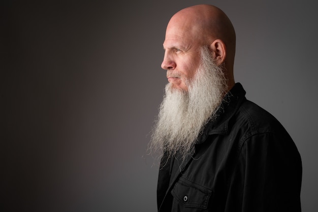 mature handsome bald man with long gray beard on white