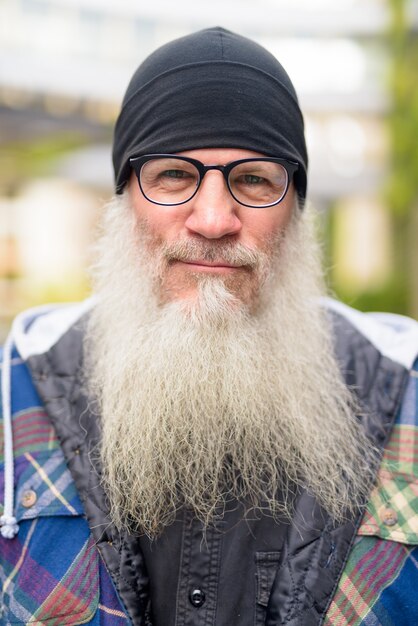 Foto uomo maturo bello barbuto hipster con occhiali all'aperto