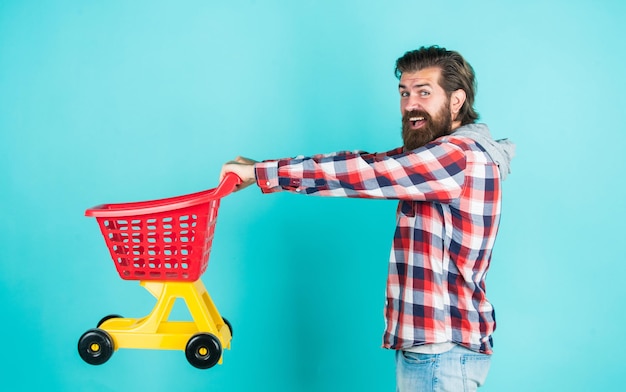 Mature handsome man in checkered shirt carry shopping cart purchase