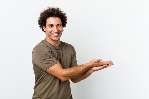 Mature handsome man isolated holding a copy space on a palm.