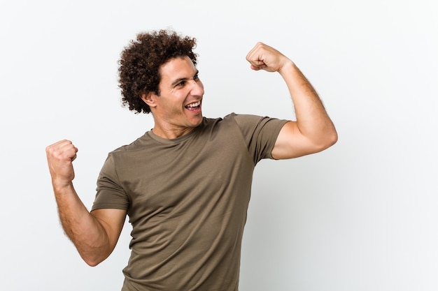 Mature handsome man isolated raising fist after a victory