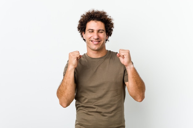 Mature handsome man isolated raising fist, feeling happy and successful