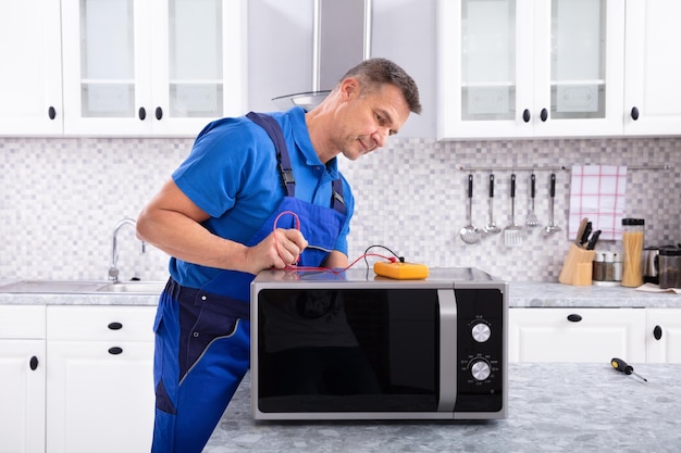 Photo mature handyman repairing microwave oven