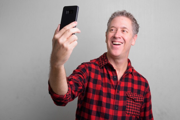 mature hipster man wearing red checkered shirt on white