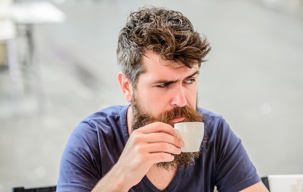 Mature hipster with beard hair drinking coffee brutal male needs morning refreshment drink espresso coffee morning breakfast Bearded man in cafe What a great morning