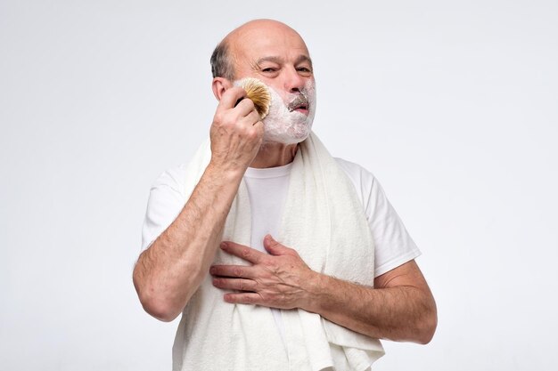 Mature hispanic man put shaving foam on beard and mustache