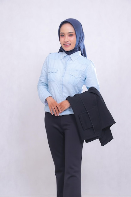 Mature indonesia office woman wearing a hijab blue shirt standing smiling cheerfully hands in front