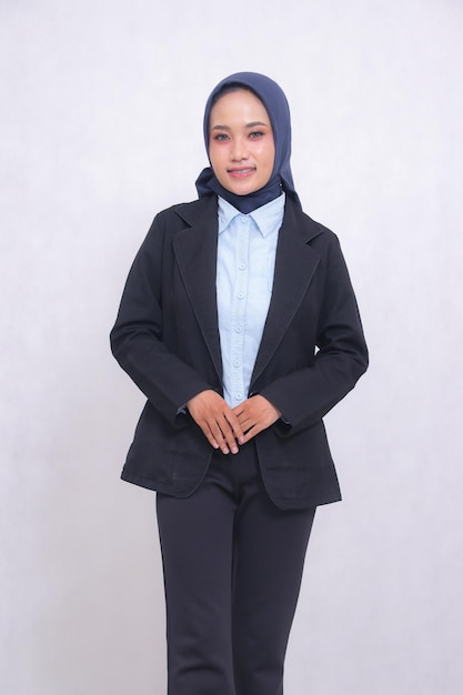 Mature indonesia office woman wearing a hijab blue shirt standing with a cheerful smile both hands i