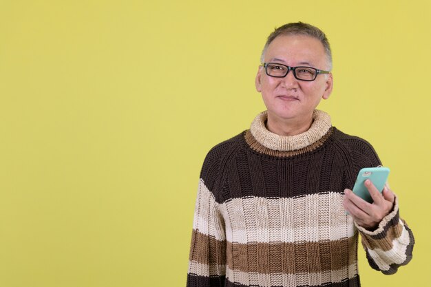  mature Japanese man with turtleneck sweater ready for winter against chroma key with green wall