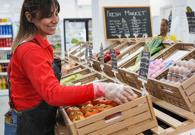 Mature latin woman working inside mini market