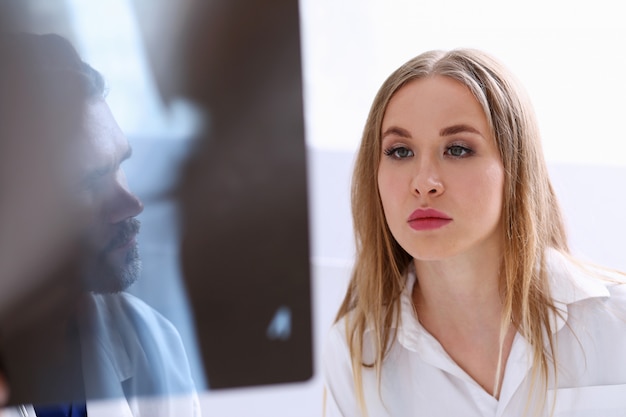 Photo mature male doctor hold in arm and look at xray photography