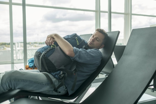 Зрелый мужчина в аэропорту спит в терминале
