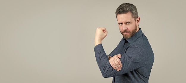 Mature man bend arm in Lshape with fist pointing upwards obscene gesture grey background Man face portrait banner with copy space
