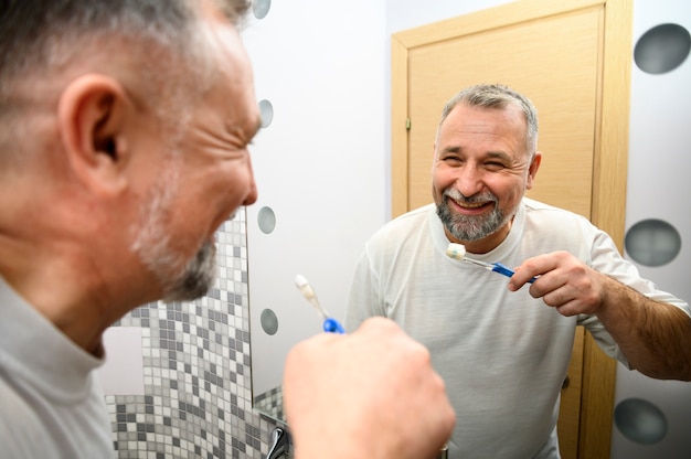 Photo mature man brushing his teeth