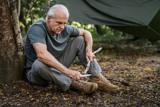 Mature man cutting some firewood